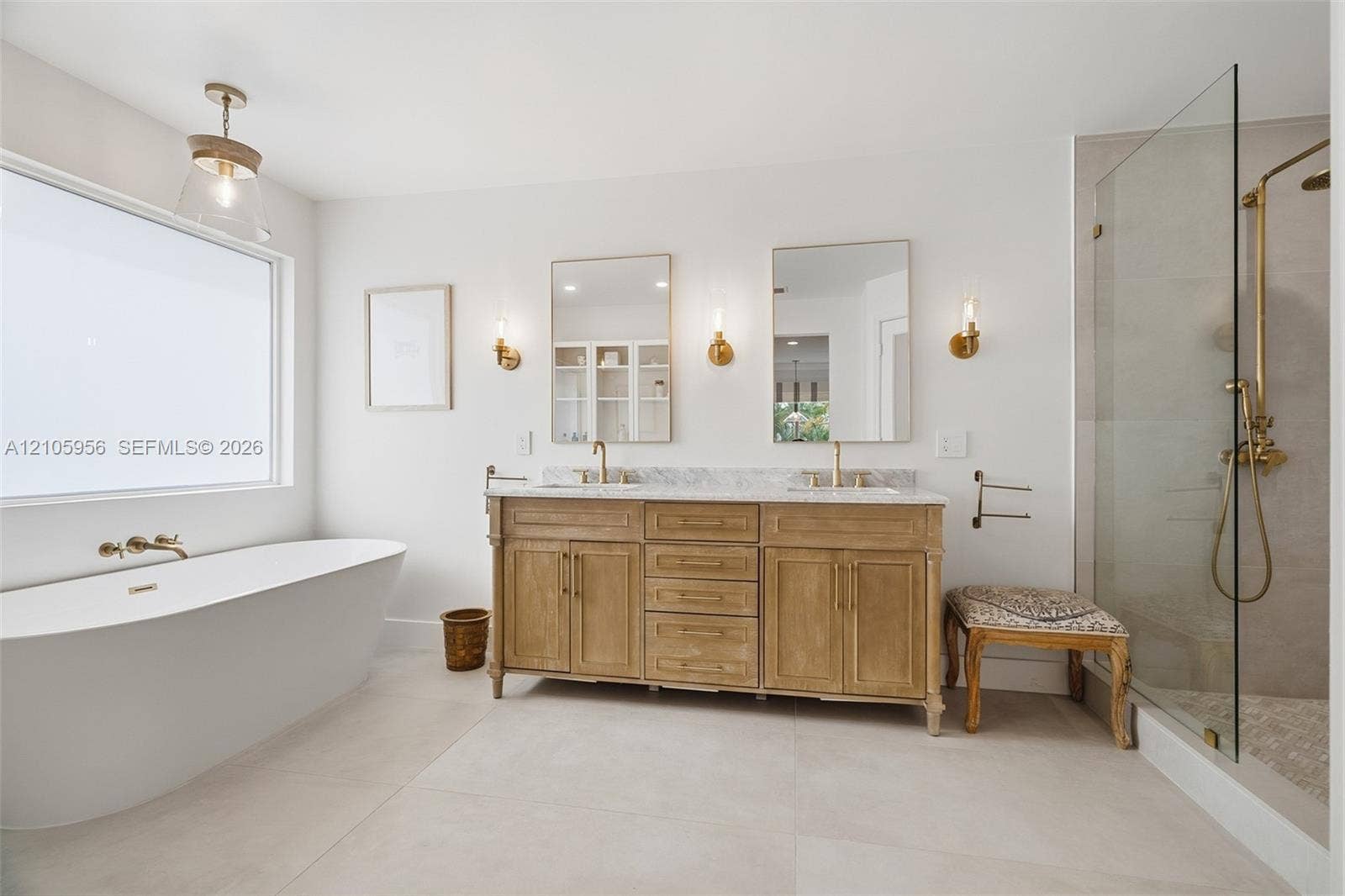 1154 Croton Court, Weston, Weston, FL 33327 Freestanding soaking tub, double-sink vanity with stone countertop, brass-finished hardware, and glass-enclosed walk-in shower