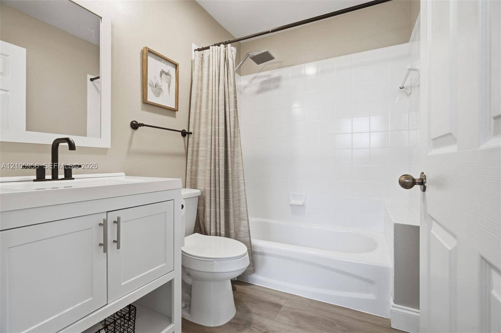 1154 Croton Court, Weston, Weston, FL 33327 Bathroom featuring a white vanity cabinet with a rectangular undermount sink, matte black faucet hardware, wood-finish flooring, and a tiled shower-tub combination