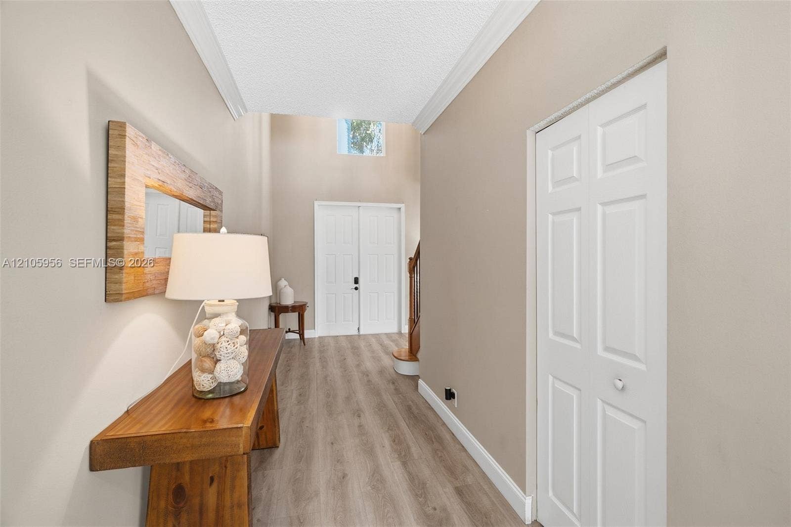 1154 Croton Court, Weston, Weston, FL 33327 Entryway featuring double-door entry, vaulted ceilings, high-placed window, wood-finish flooring, and a multi-panel bi-fold closet door