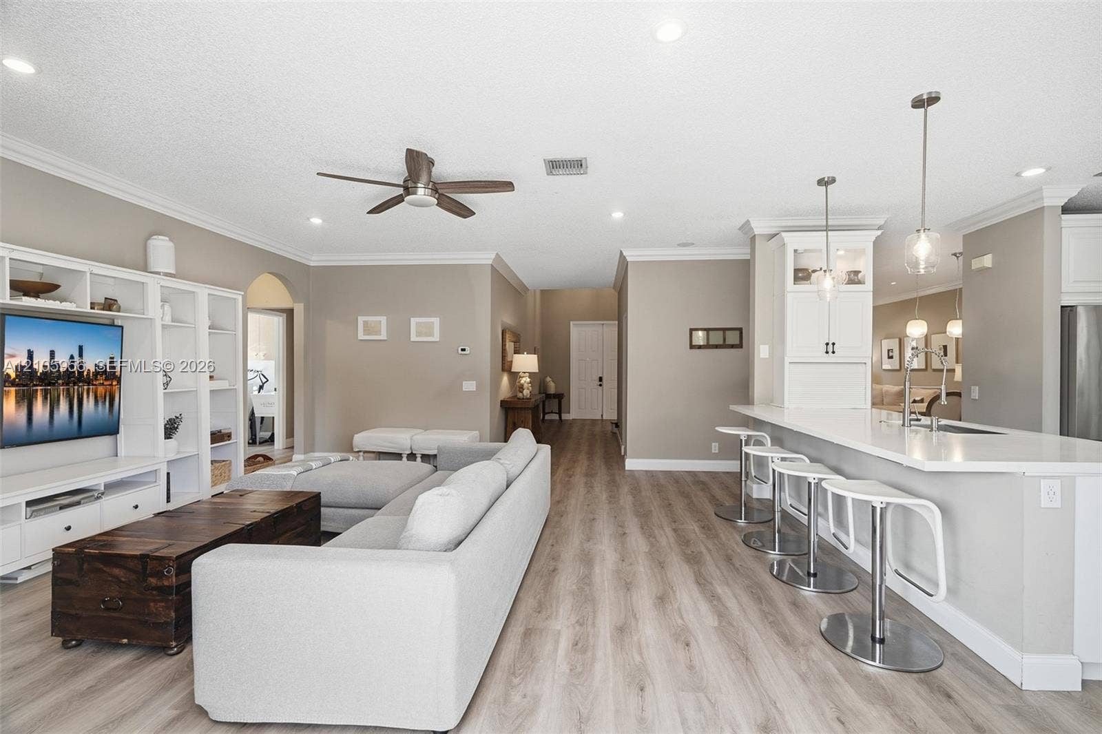 1154 Croton Court, Weston, Weston, FL 33327 Open-concept interior featuring wood-finish flooring, built-in cabinetry, recessed lighting, and a breakfast bar with stone-surface countertops and pendant lighting