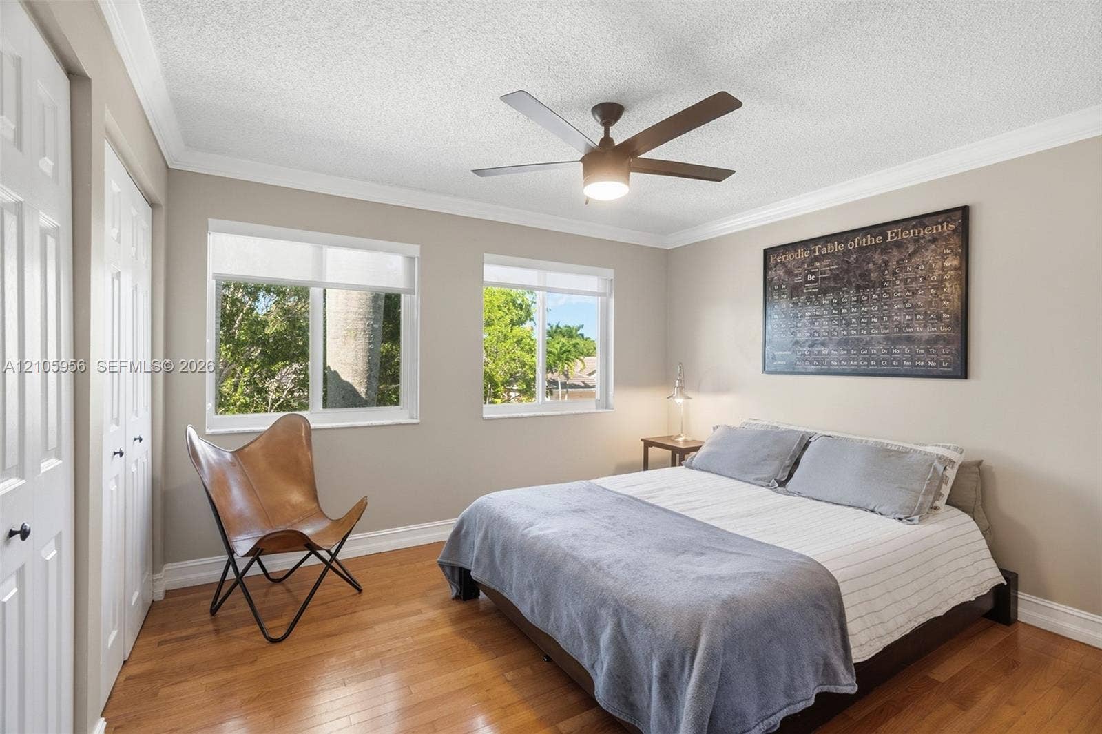1154 Croton Court, Weston, Weston, FL 33327 Room featuring wood-finish flooring, dual windows with roller shades, ceiling fan with integrated lighting, and multi-panel closet doors