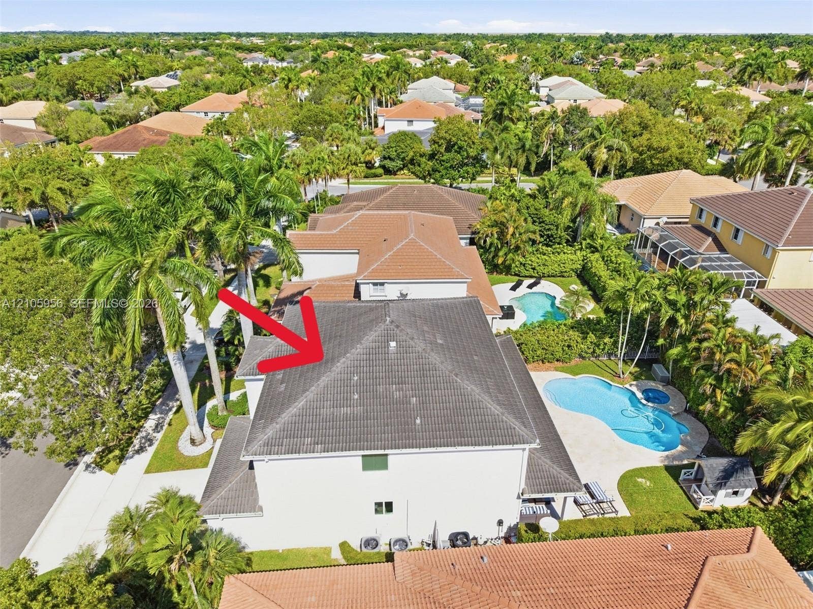 1154 Croton Court, Weston, Weston, FL 33327 Aerial perspective of two-story residence featuring a tile roof, swimming pool with integrated spa, concrete pool deck, and mature palm trees