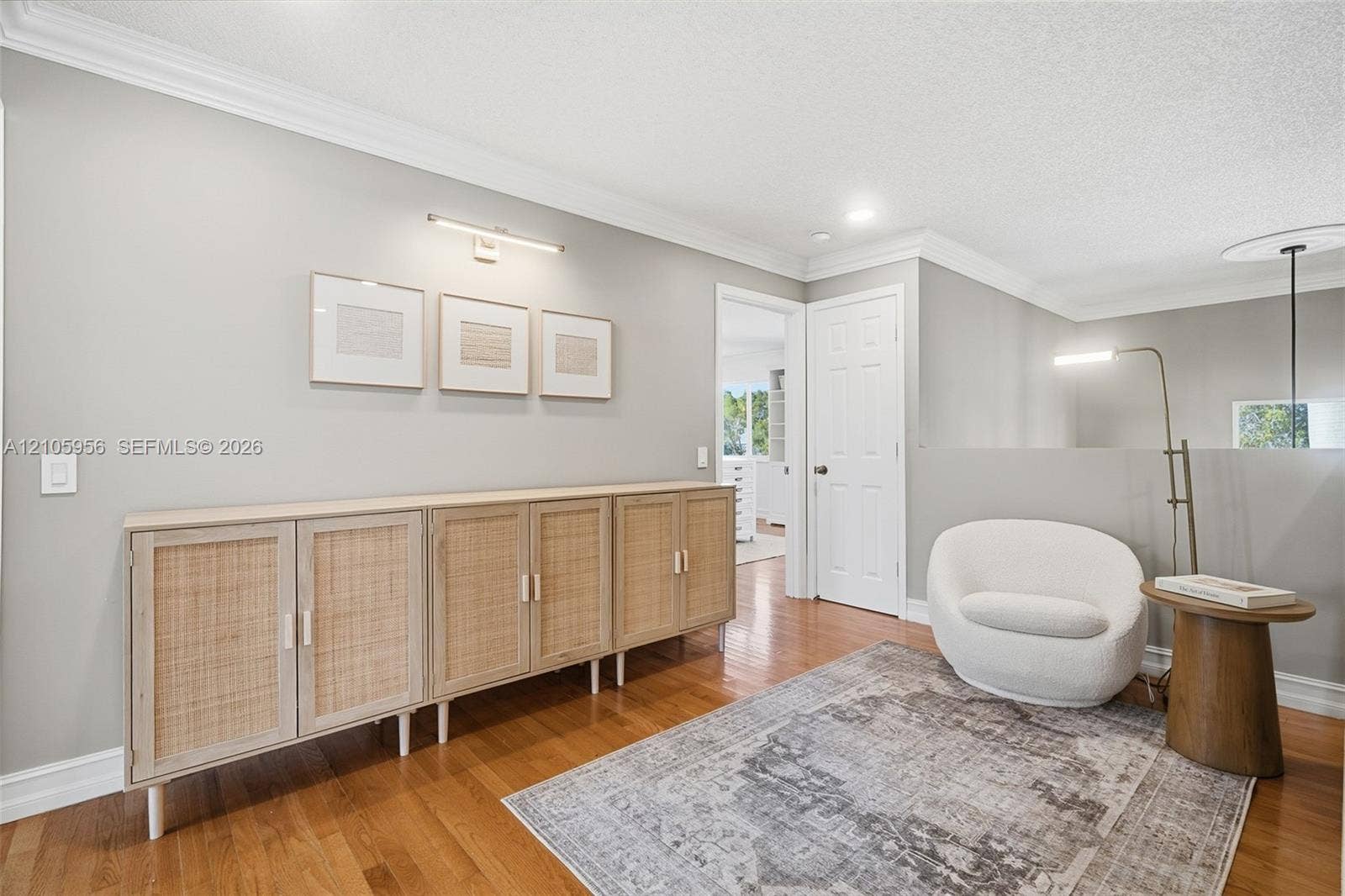 1154 Croton Court, Weston, Weston, FL 33327 Interior space featuring wood-finish flooring, crown molding, a built-in multi-door cabinetry unit, and a wall-mounted picture light