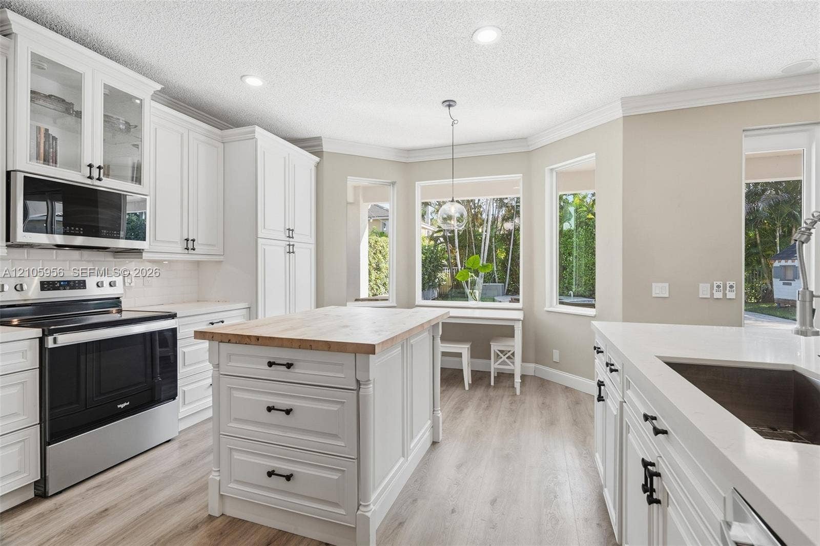 1154 Croton Court, Weston, Weston, FL 33327 Kitchen featuring white shaker-style cabinetry, wood-top center island, stone-surfaced countertops, stainless steel appliances, and wood-finish flooring