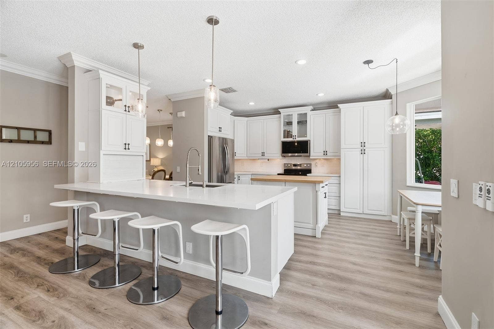 1154 Croton Court, Weston, Weston, FL 33327 Kitchen featuring white shaker-style cabinetry, quartz countertops, a central island with a wood-finish surface, wood-finish flooring, and recessed pendant lighting