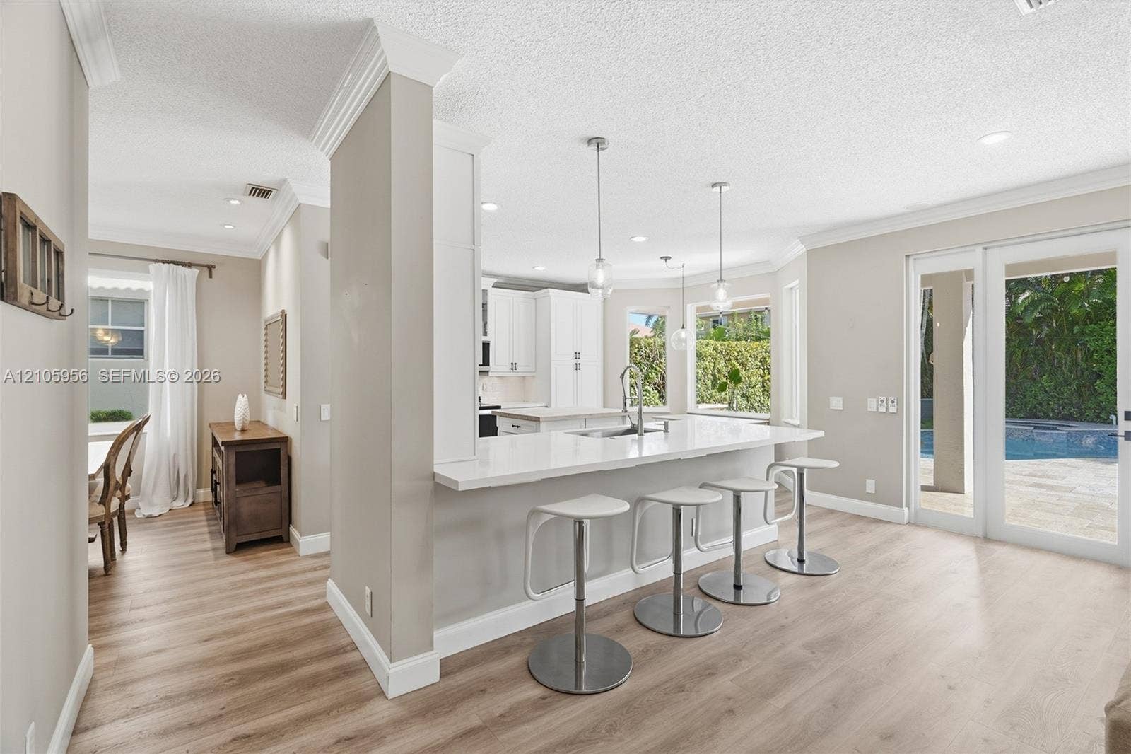 1154 Croton Court, Weston, Weston, FL 33327 Kitchen featuring white shaker-style cabinetry, quartz countertops with a breakfast bar, stainless steel undermount sink, wood-finish flooring, and recessed lighting