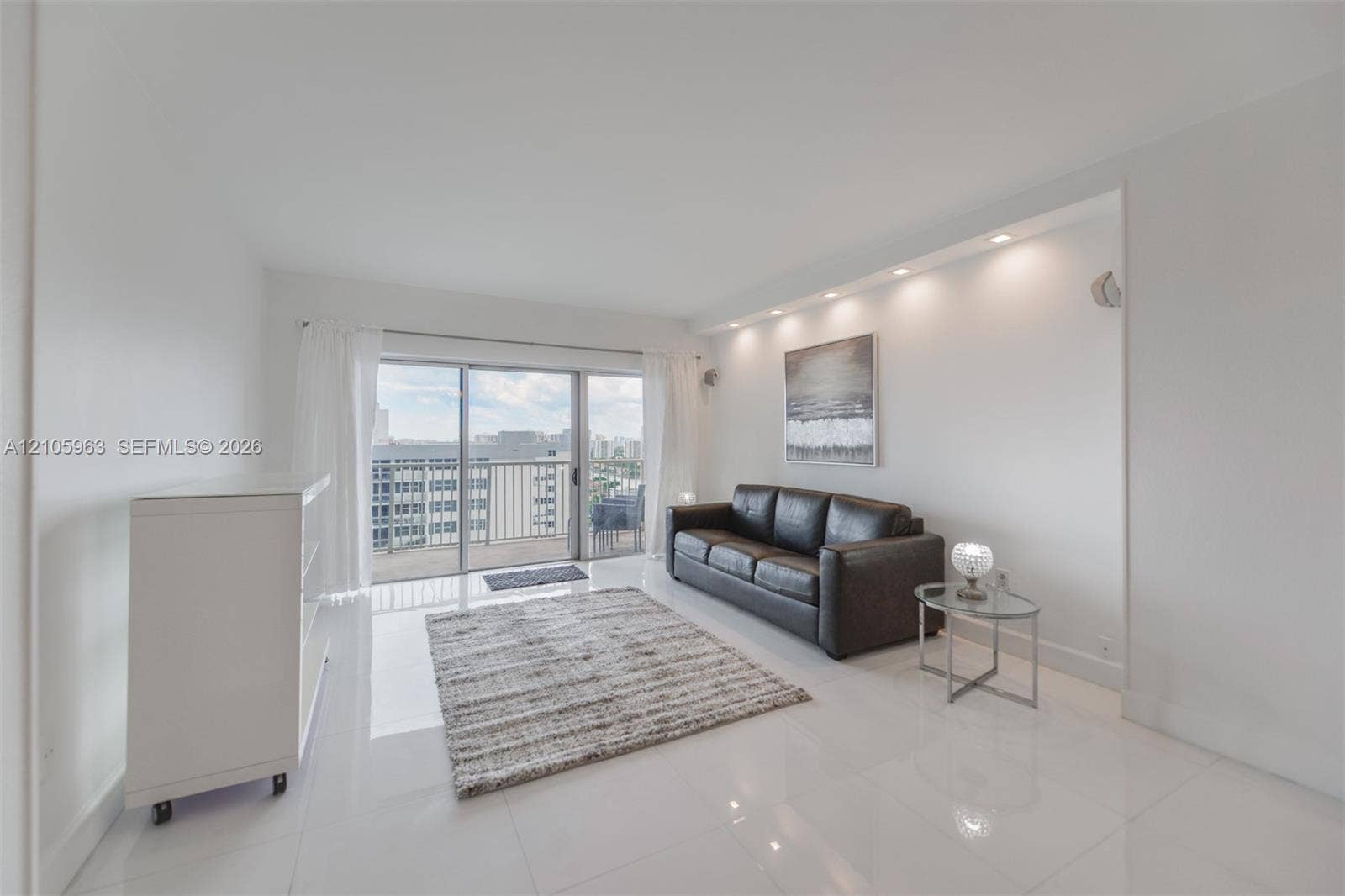 1980 S Ocean Drive, #PHA, Hallandale Beach, Hallandale Beach, FL 33009 Living area featuring polished tile flooring, recessed ceiling lighting, and a large sliding glass door opening to a balcony