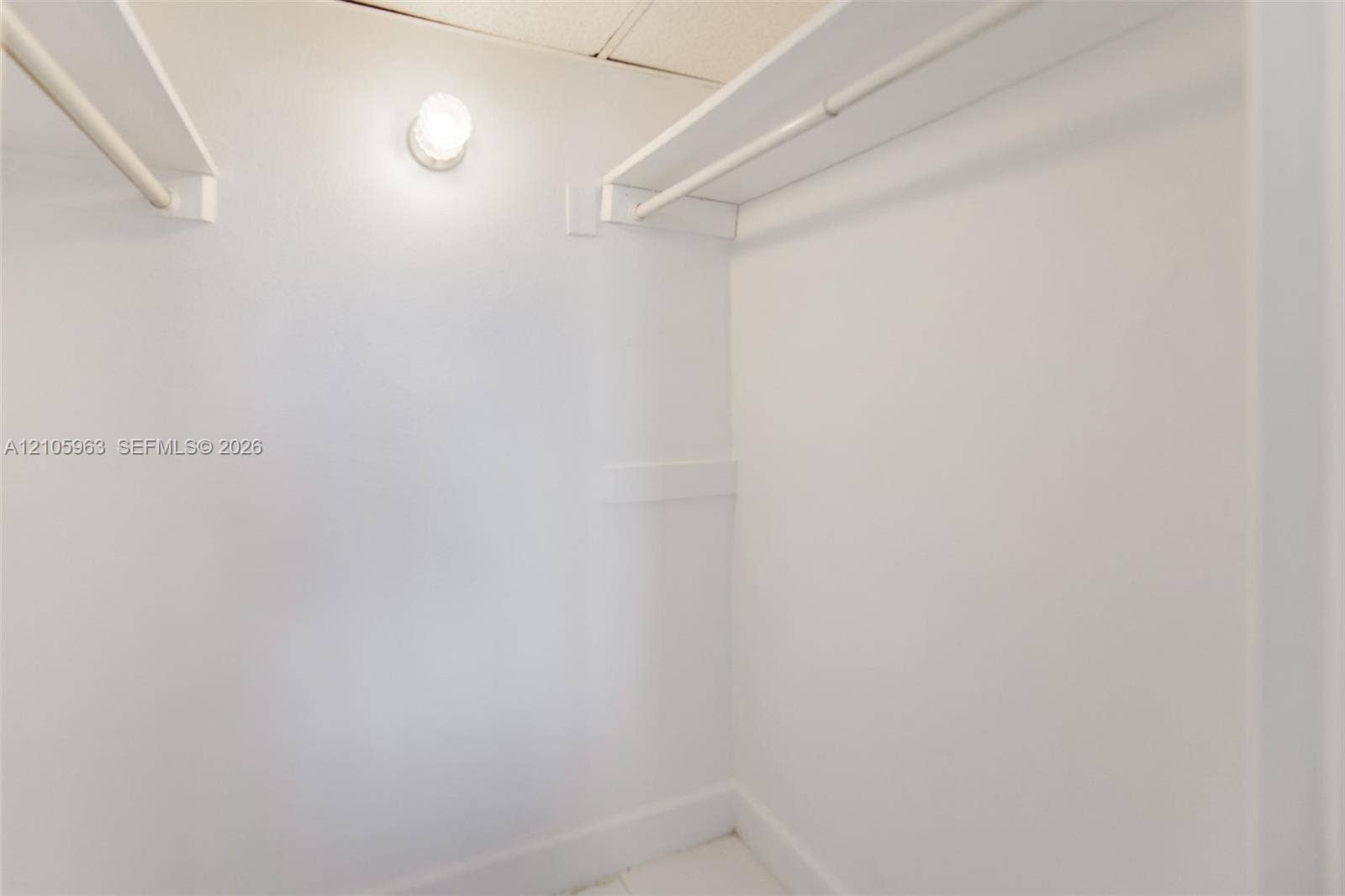 1980 S Ocean Drive, #PHA, Hallandale Beach, Hallandale Beach, FL 33009 Walk-in closet featuring white walls, dual built-in shelving units, integrated hanging rods, and a ceiling-mounted light fixture