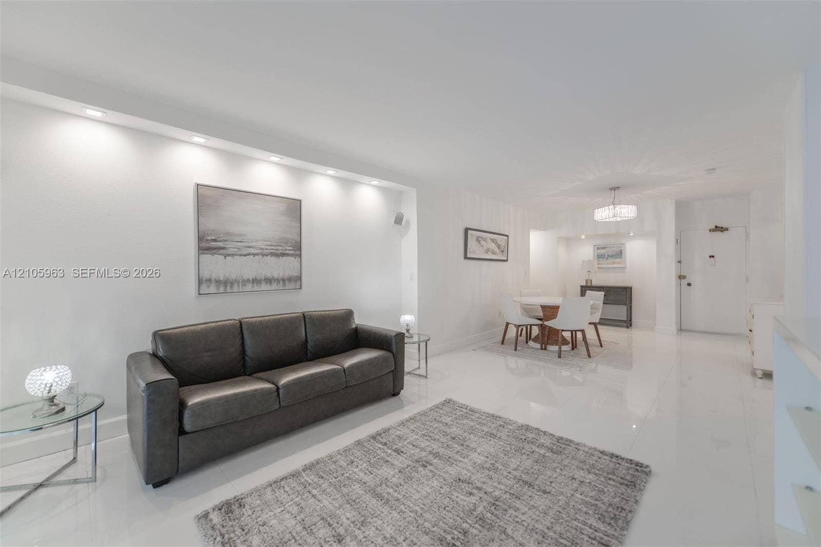1980 S Ocean Drive, #PHA, Hallandale Beach, Hallandale Beach, FL 33009 Bright living area featuring high-gloss flooring, recessed ceiling lighting, and a custom architectural soffit with integrated downlighting