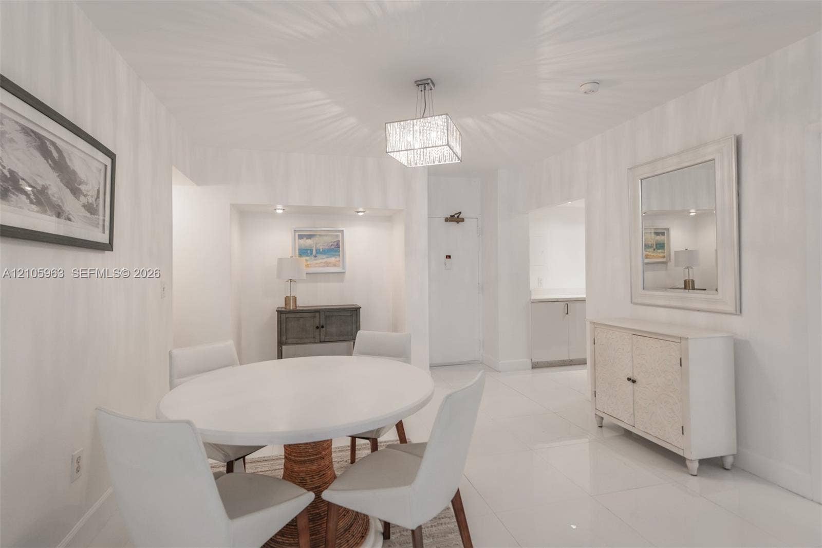 1980 S Ocean Drive, #PHA, Hallandale Beach, Hallandale Beach, FL 33009 Formal dining area featuring large-format tile flooring, a geometric crystal pendant light, and a recessed wall niche with integrated spot lighting