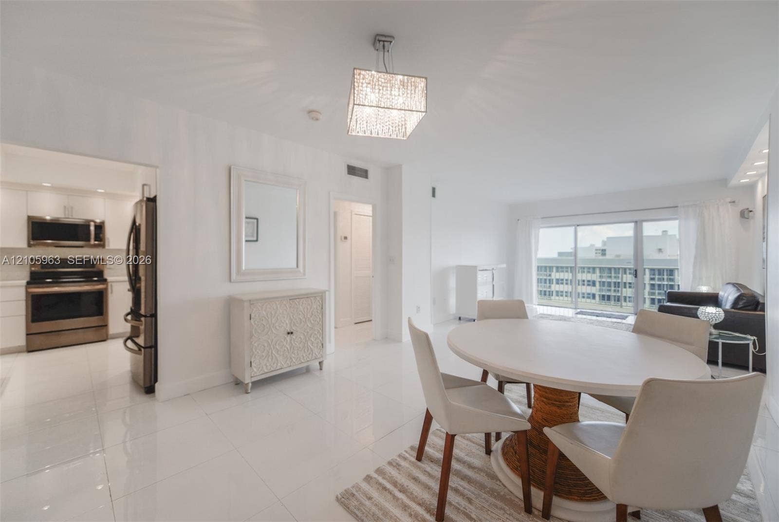 1980 S Ocean Drive, #PHA, Hallandale Beach, Hallandale Beach, FL 33009 Open-concept living space featuring high-gloss tile flooring, recessed lighting, a modern square crystal chandelier, and large sliding glass doors providing natural light