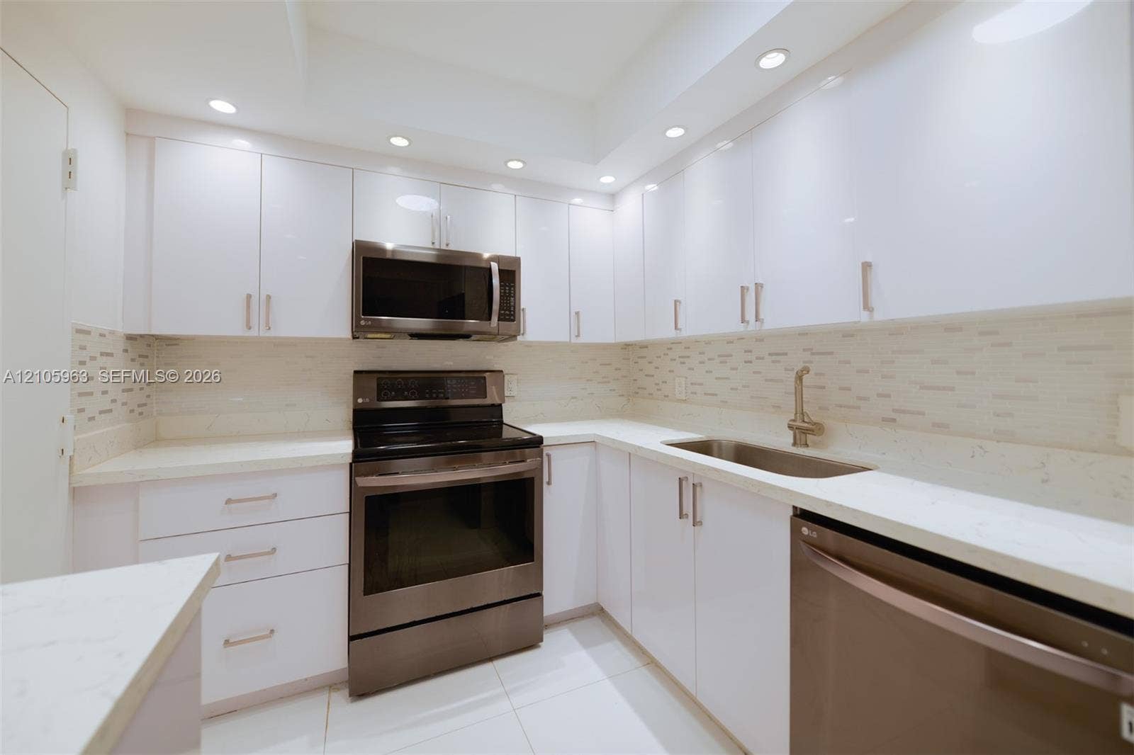 1980 S Ocean Drive, #PHA, Hallandale Beach, Hallandale Beach, FL 33009 Kitchen featuring white high-gloss cabinetry, stainless steel appliances, white solid-surface countertops, mosaic tile backsplash, and recessed lighting