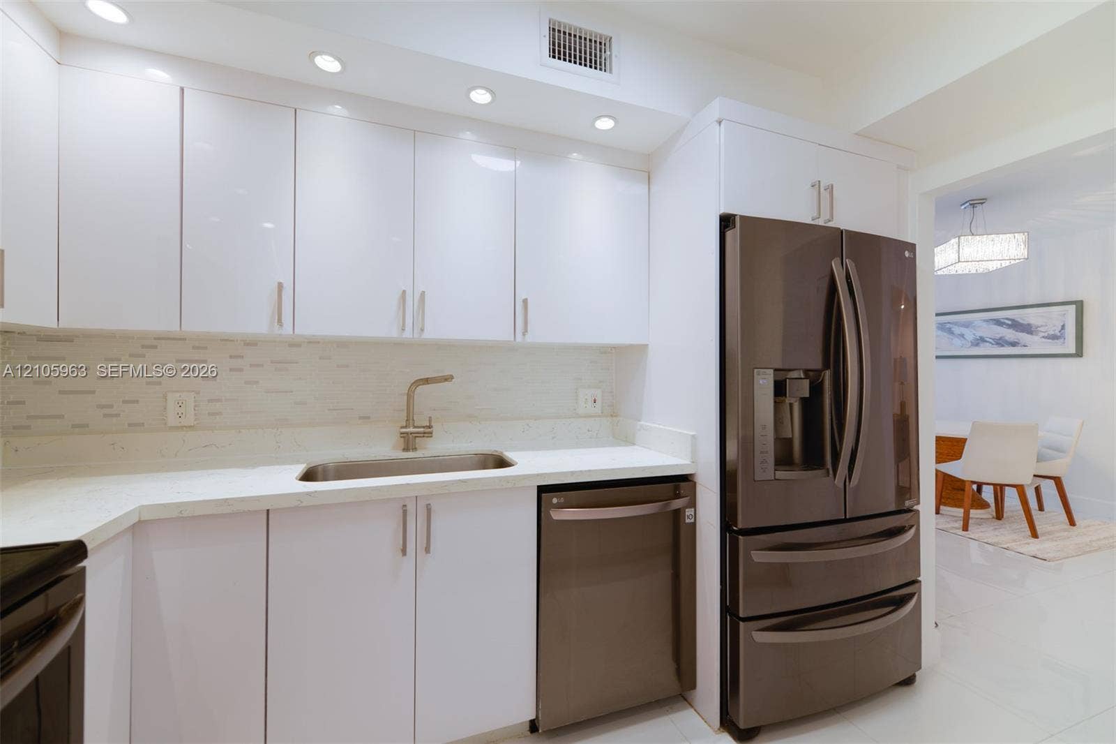 1980 S Ocean Drive, #PHA, Hallandale Beach, Hallandale Beach, FL 33009 Kitchen featuring high-gloss white cabinetry, light-toned stone-surface countertops, a mosaic tile backsplash, stainless steel appliances, and recessed lighting
