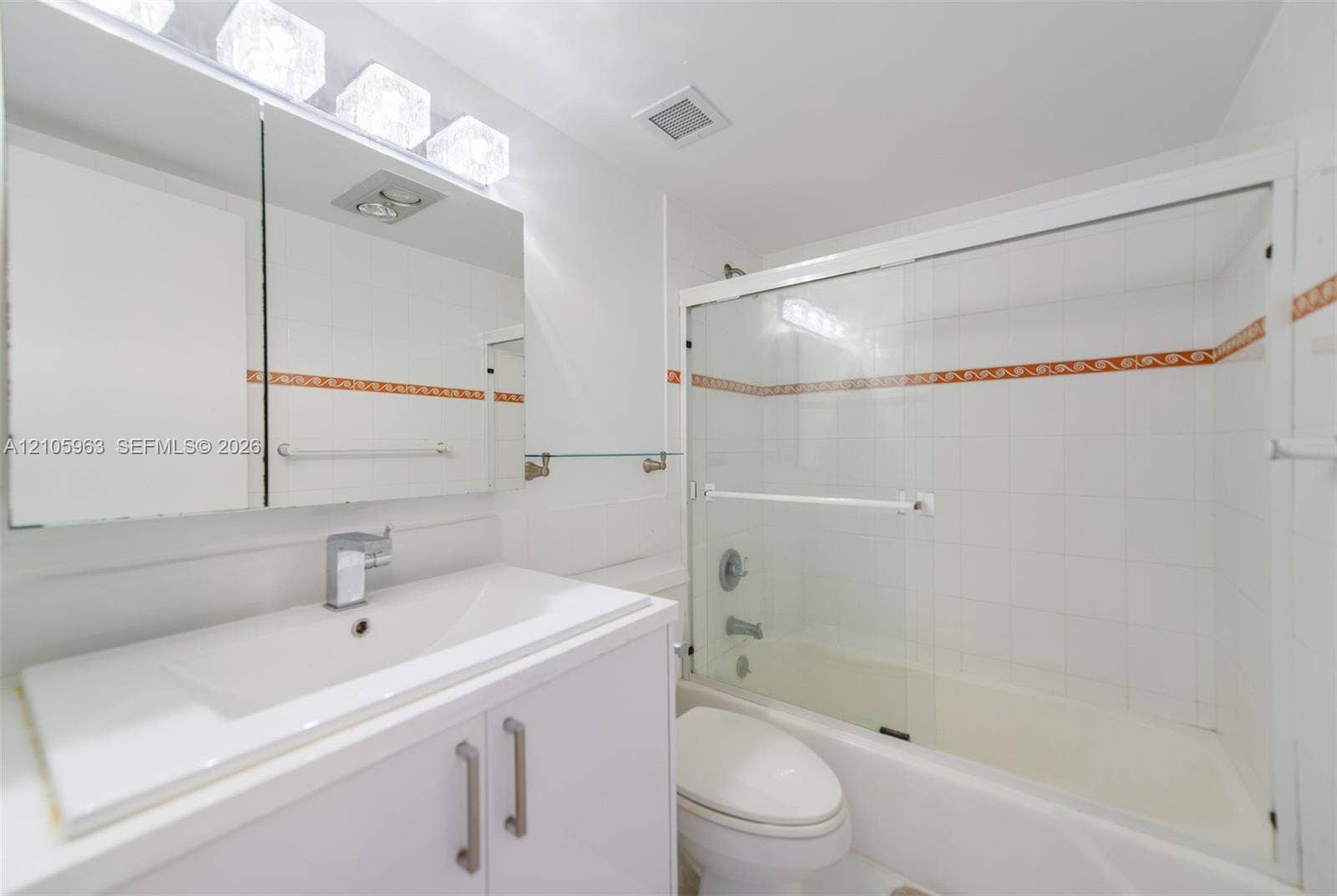 1980 S Ocean Drive, #PHA, Hallandale Beach, Hallandale Beach, FL 33009 Bathroom featuring a vanity with an integrated sink, tri-light fixture, medicine cabinet, and a tub-shower combination enclosed by glass sliding doors