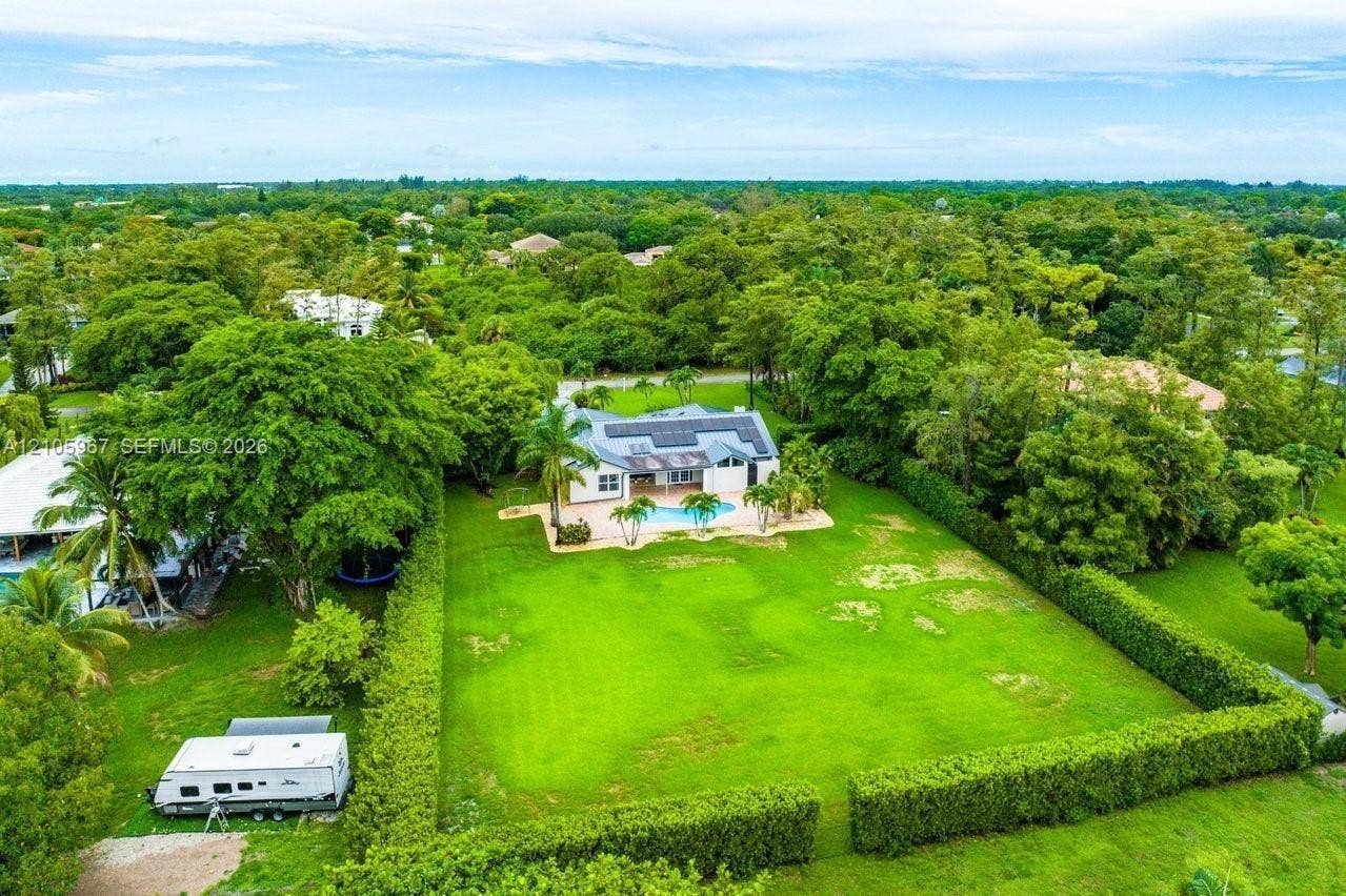 5966 NW 77th Terrace, Parkland, Parkland, FL 33067 Expansive lot featuring a structured hedge perimeter, swimming pool, and roof-mounted solar panels