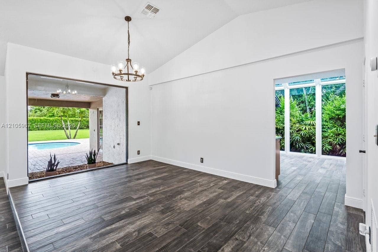 5966 NW 77th Terrace, Parkland, Parkland, FL 33067 Vaulted ceilings, wood-finish flooring, and a multi-arm chandelier