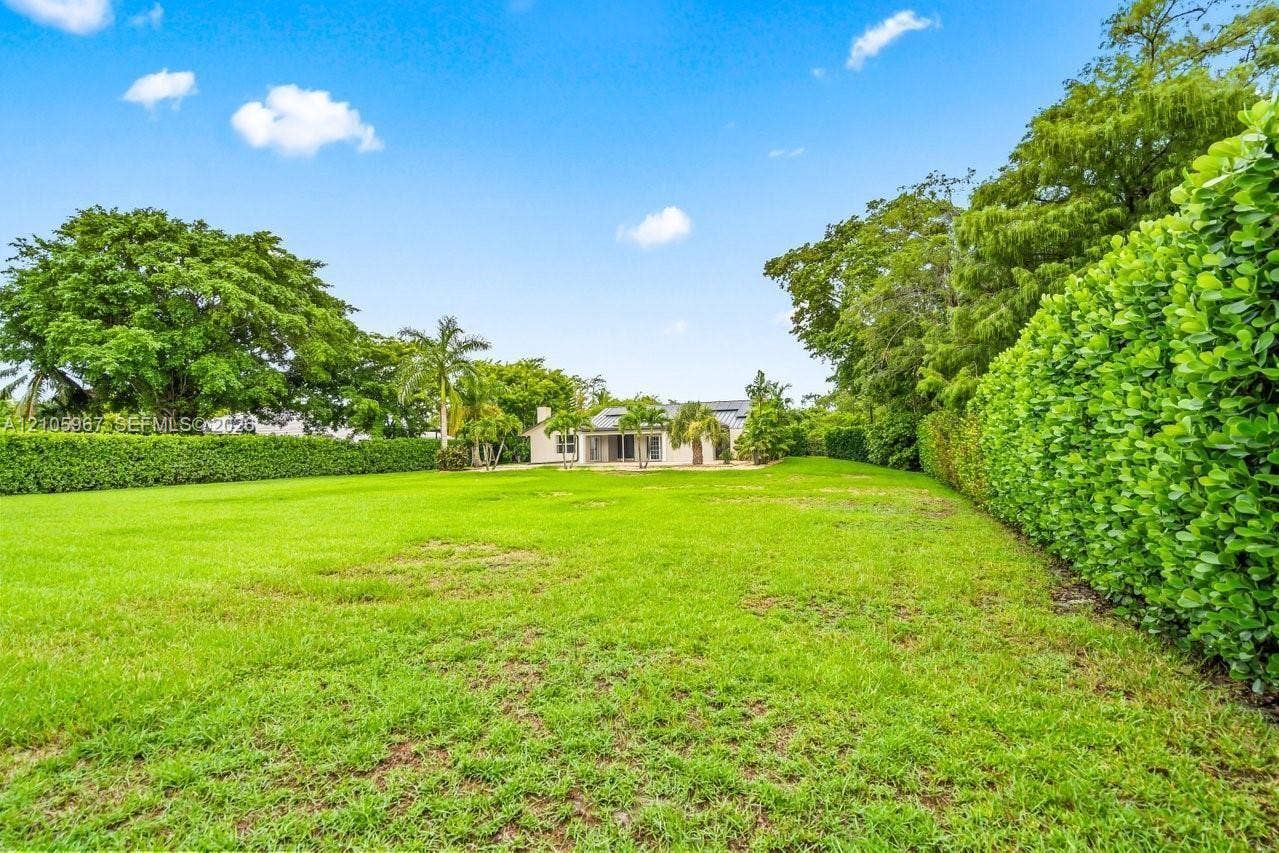 5966 NW 77th Terrace, Parkland, Parkland, FL 33067 Expansive backyard featuring a manicured lawn, perimeter privacy hedging, and mature trees