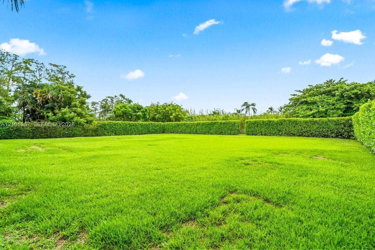 5966 NW 77th Terrace, Parkland, Parkland, FL 33067 Expansive level lawn enclosed by mature perimeter hedging and surrounding tropical foliage