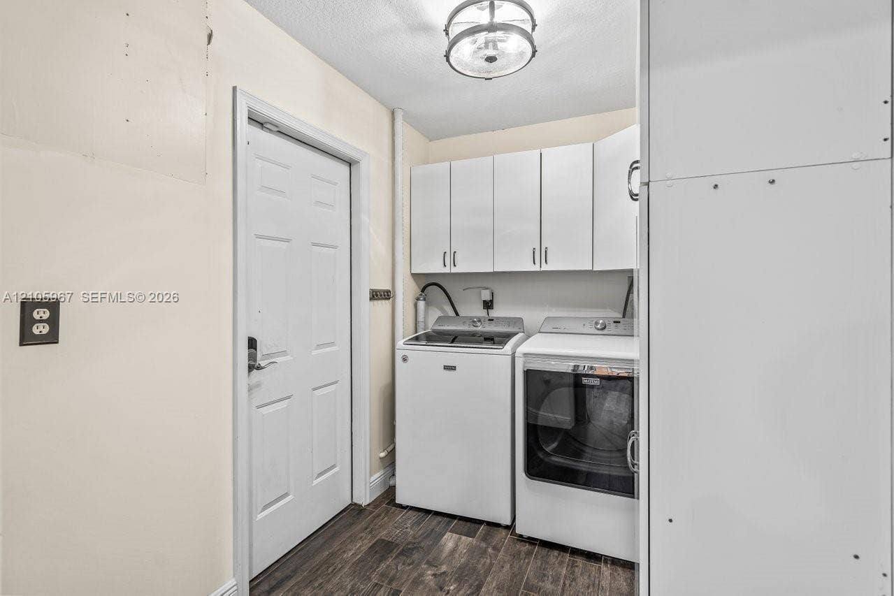 5966 NW 77th Terrace, Parkland, Parkland, FL 33067 Laundry area featuring white built-in upper cabinetry, wood-finish flooring, and a semi-flush mount ceiling light fixture