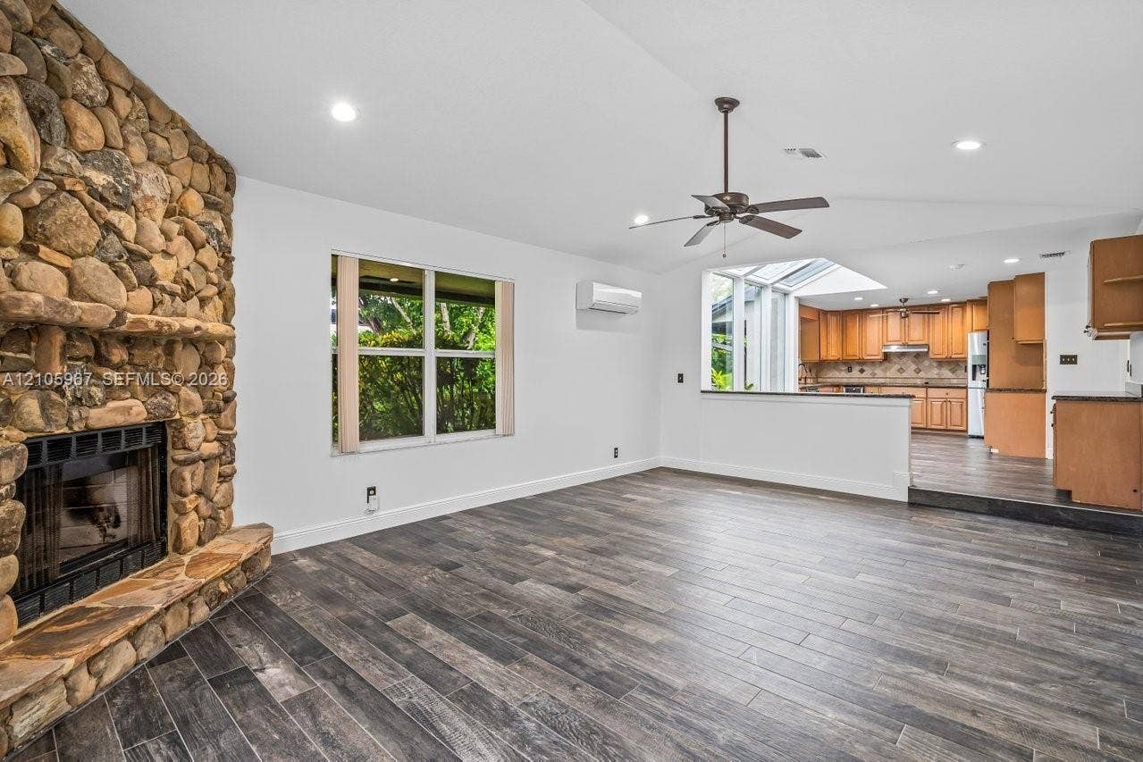 5966 NW 77th Terrace, Parkland, Parkland, FL 33067 Full-height floor-to-ceiling river stone fireplace, wood-finish tile flooring, recessed lighting, ceiling fan, and wall-mounted ductless heating and cooling unit