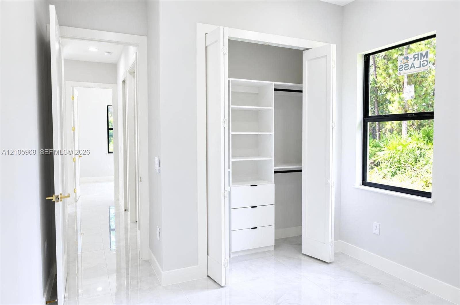 3509 63rd Street W, Lehigh Acres, FL 33971 Custom closet featuring built-in shelving and drawers, large-format tile flooring, and black-framed window