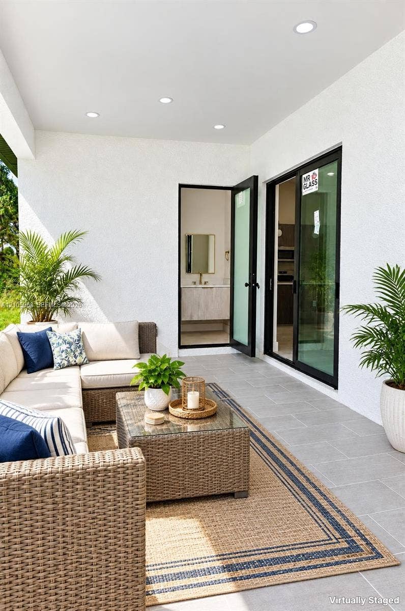 3509 63rd Street W, Lehigh Acres, FL 33971 Covered patio featuring large-format ceramic tile flooring, recessed lighting, and black-framed sliding glass doors