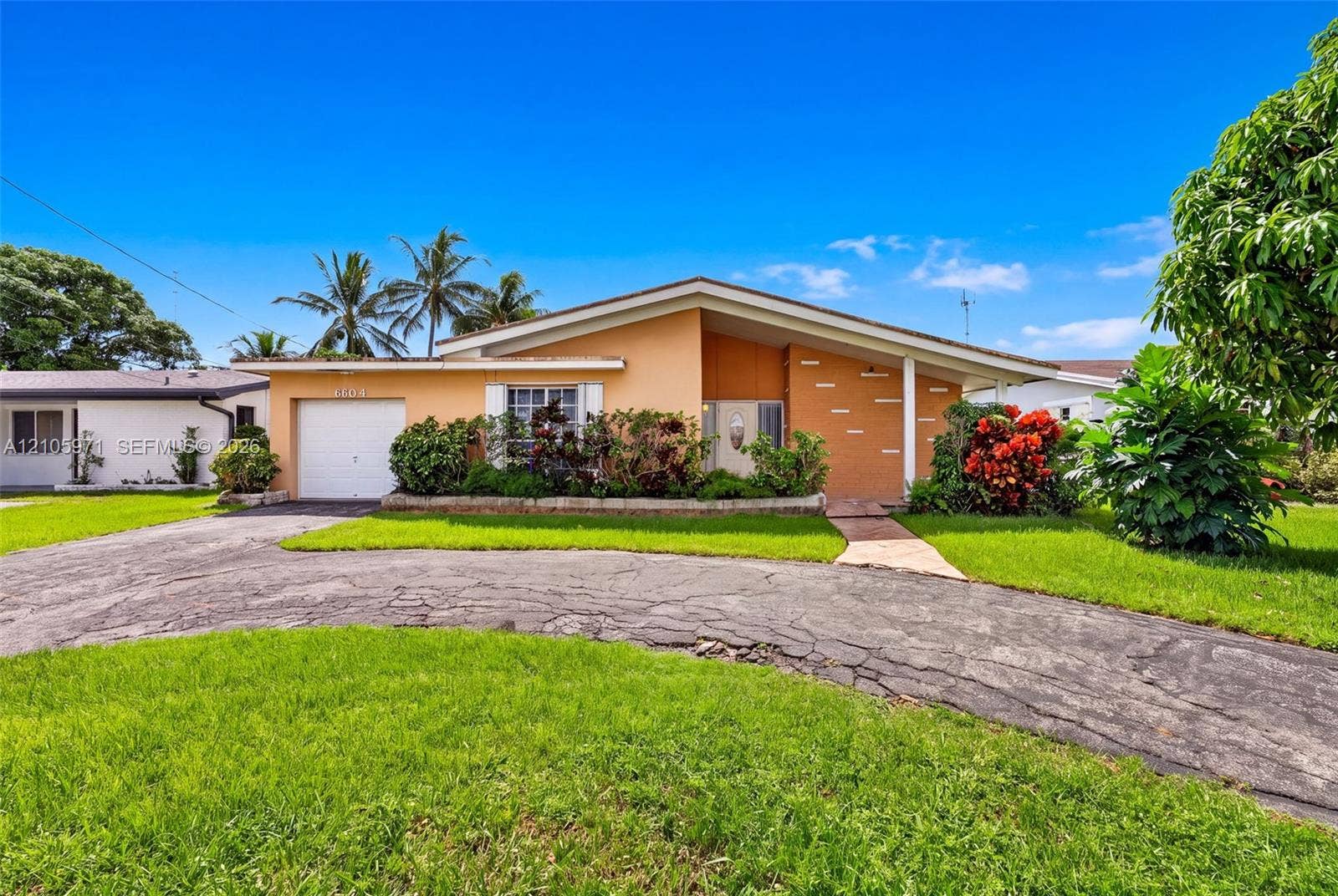 6604 Coconut Drive, Miramar, FL 33023 Single-story residence featuring a low-slope roofline, attached garage, concrete driveway, and ornamental exterior brick detailing