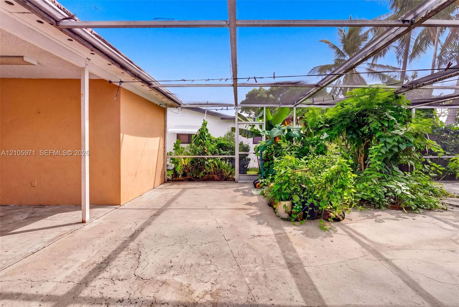 6604 Coconut Drive, Miramar, FL 33023 Enclosed patio featuring a concrete floor, metal framing, and mesh screening