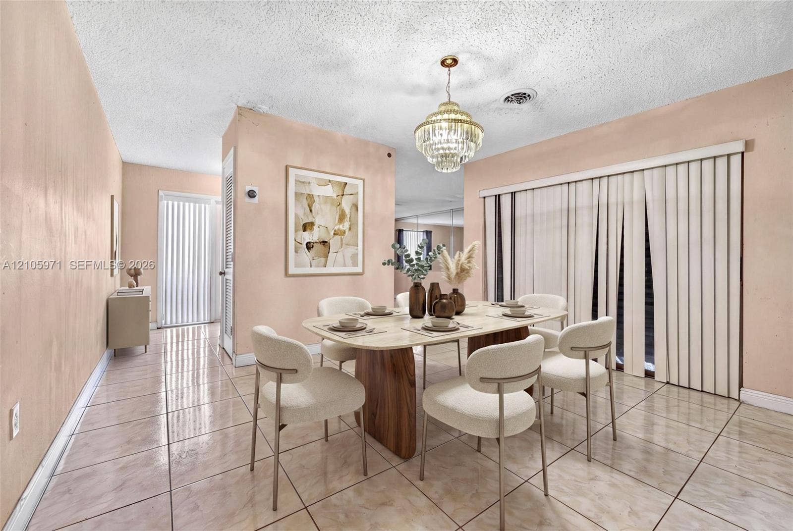 6604 Coconut Drive, Miramar, FL 33023 Dining area featuring polished tile flooring, a multi-tiered crystal chandelier, vertical blinds, and a built-in mirrored wall panel
