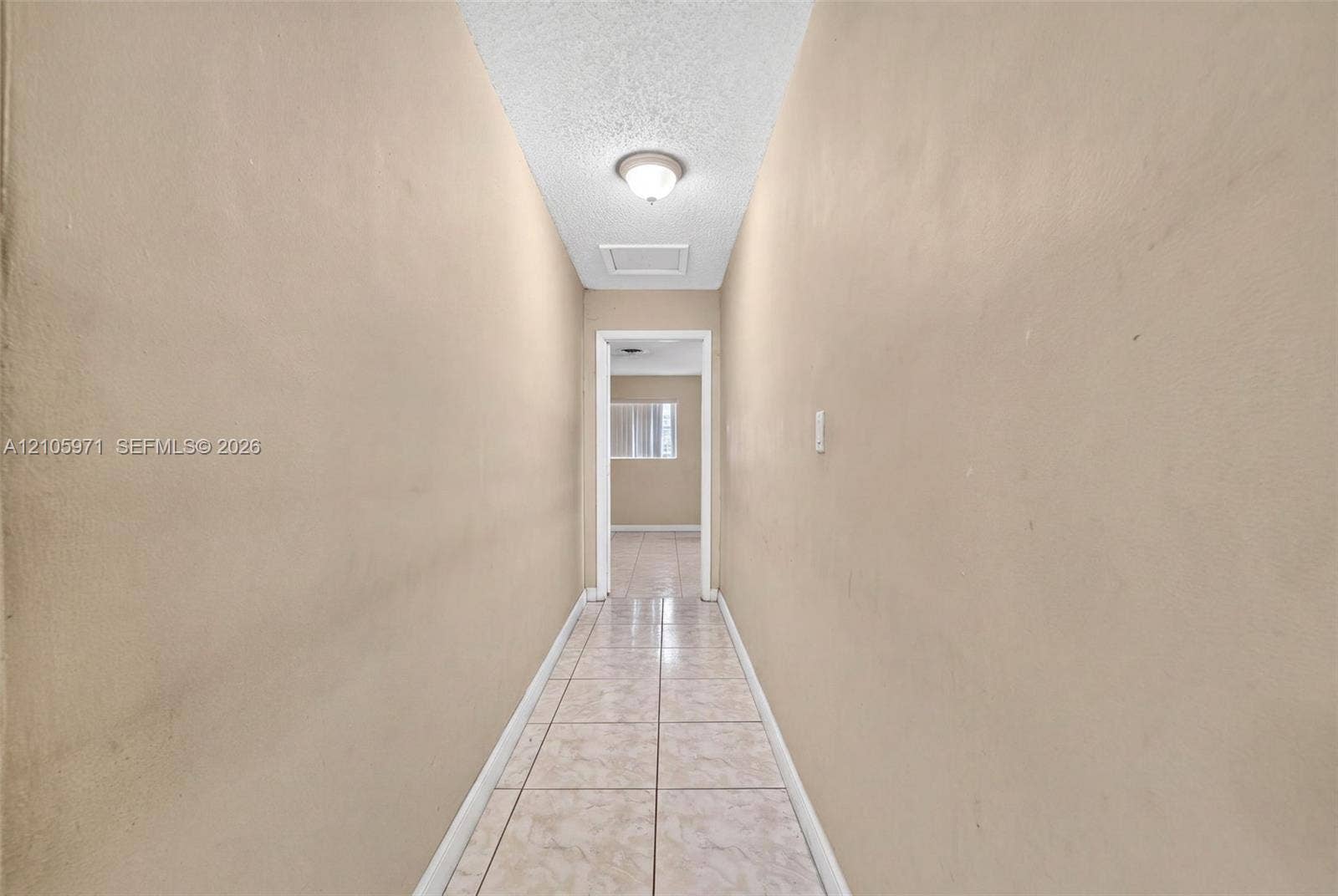6604 Coconut Drive, Miramar, FL 33023 Hallway featuring neutral-toned walls, tile flooring, and a ceiling-mounted light fixture