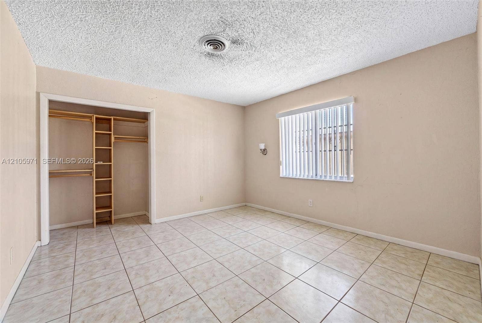 6604 Coconut Drive, Miramar, FL 33023 Room featuring tile flooring, a window with vertical blinds, and a built-in closet with integrated shelving