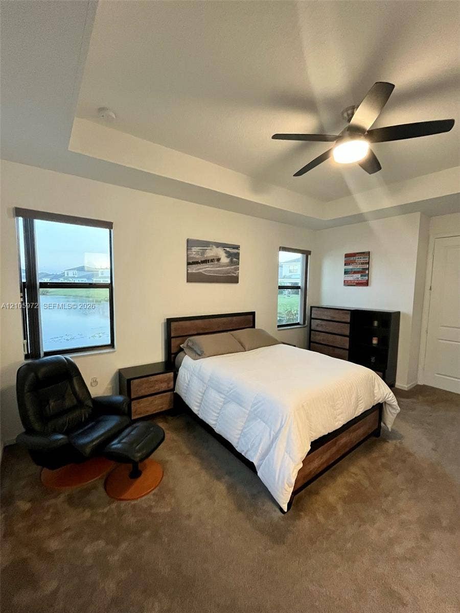 6220 Oceanaire Way, Lake Worth, FL 33467 Tray ceiling with central light fixture, wall-to-wall carpeting, and dual windows