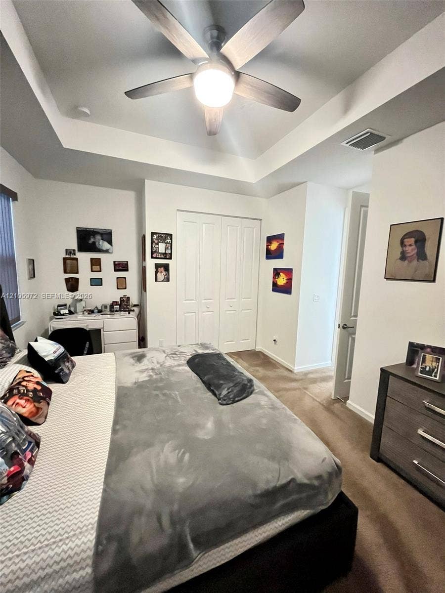 6220 Oceanaire Way, Lake Worth, FL 33467 Tray ceiling featuring a central multi-blade ceiling fan with integrated lighting and double-door closet cabinetry
