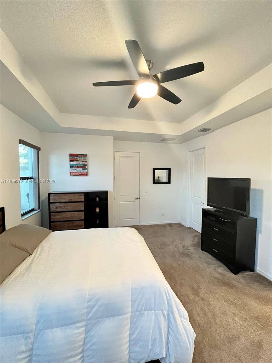 6220 Oceanaire Way, Lake Worth, FL 33467 Tray ceiling with a central multi-blade ceiling fan and wall-to-wall carpeting