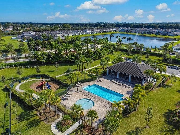6220 Oceanaire Way, Lake Worth, FL 33467 Community amenities including a swimming pool with spa, covered pavilion, and playground, situated on expansive grounds featuring a central lake