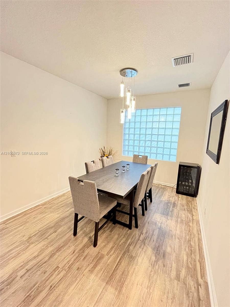 6220 Oceanaire Way, Lake Worth, FL 33467 Wood-finish flooring, glass block window, and multi-pendant light fixture