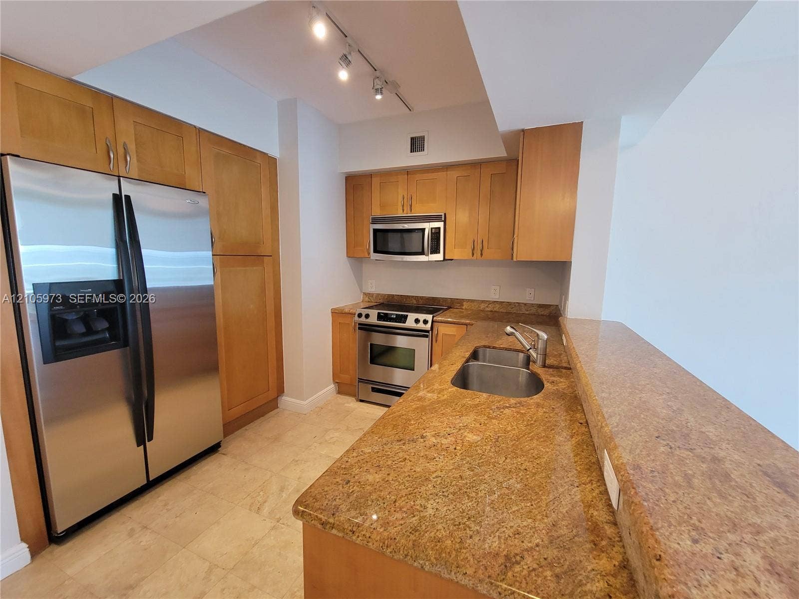 1755 E Hallandale Beach Boulevard, #704E, Hallandale Beach, Hallandale Beach, FL 33009 Kitchen featuring stone countertops, wood-finish cabinetry, stainless steel appliances, a double-basin undermount sink, and track lighting