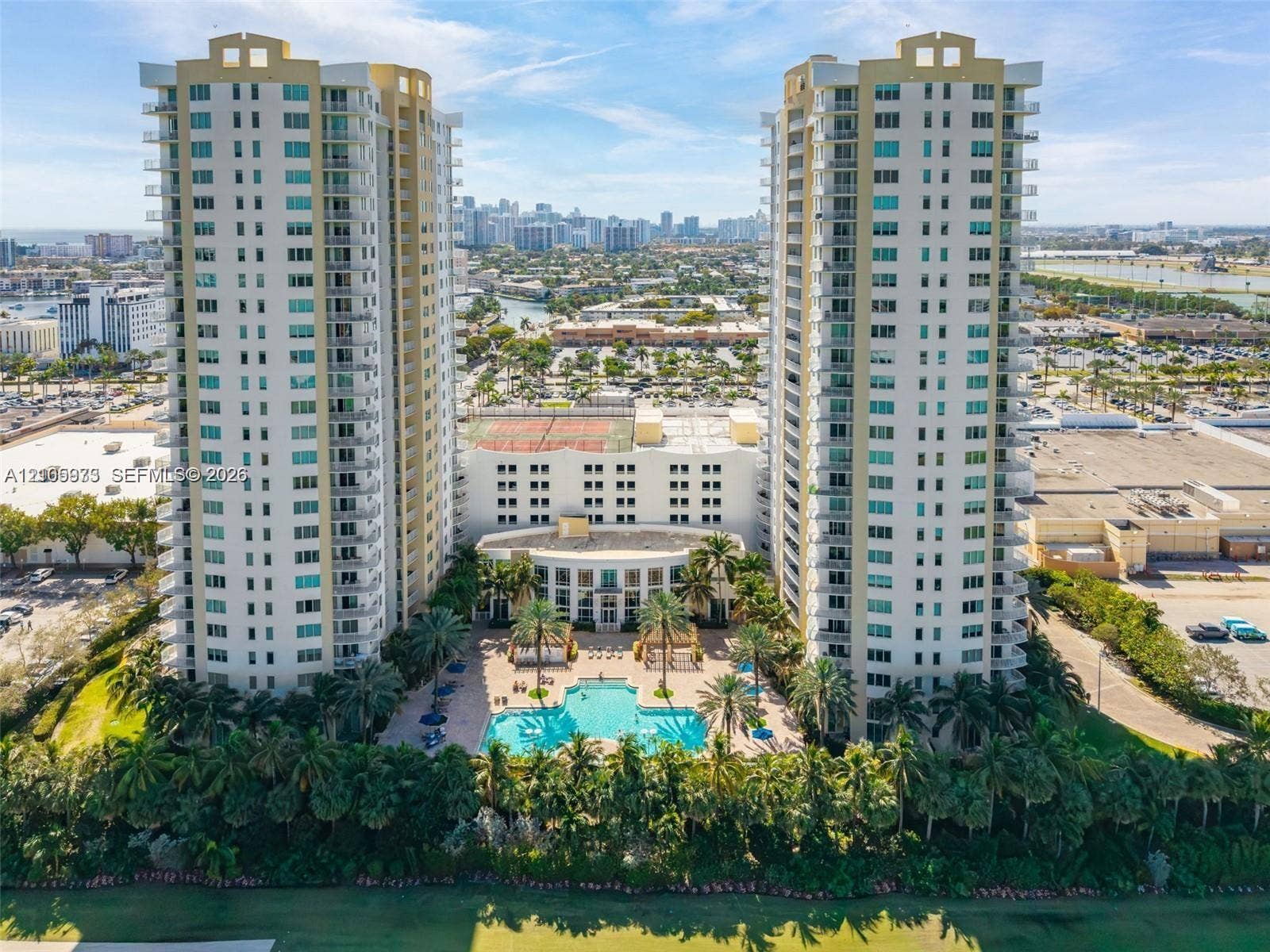 1755 E Hallandale Beach Boulevard, #704E, Hallandale Beach, Hallandale Beach, FL 33009 High-rise residential towers featuring multiple wrap-around balconies, a ground-level swimming pool, hardscaped patio areas, and tennis courts