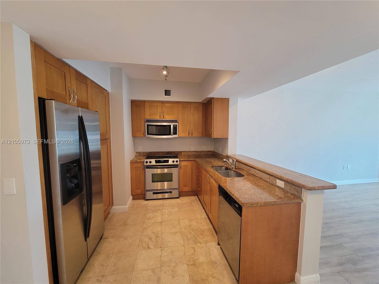 1755 E Hallandale Beach Boulevard, #704E, Hallandale Beach, Hallandale Beach, FL 33009 Kitchen featuring natural wood cabinetry, stone countertops, stainless steel appliances, a double-basin undermount sink, and tiled flooring