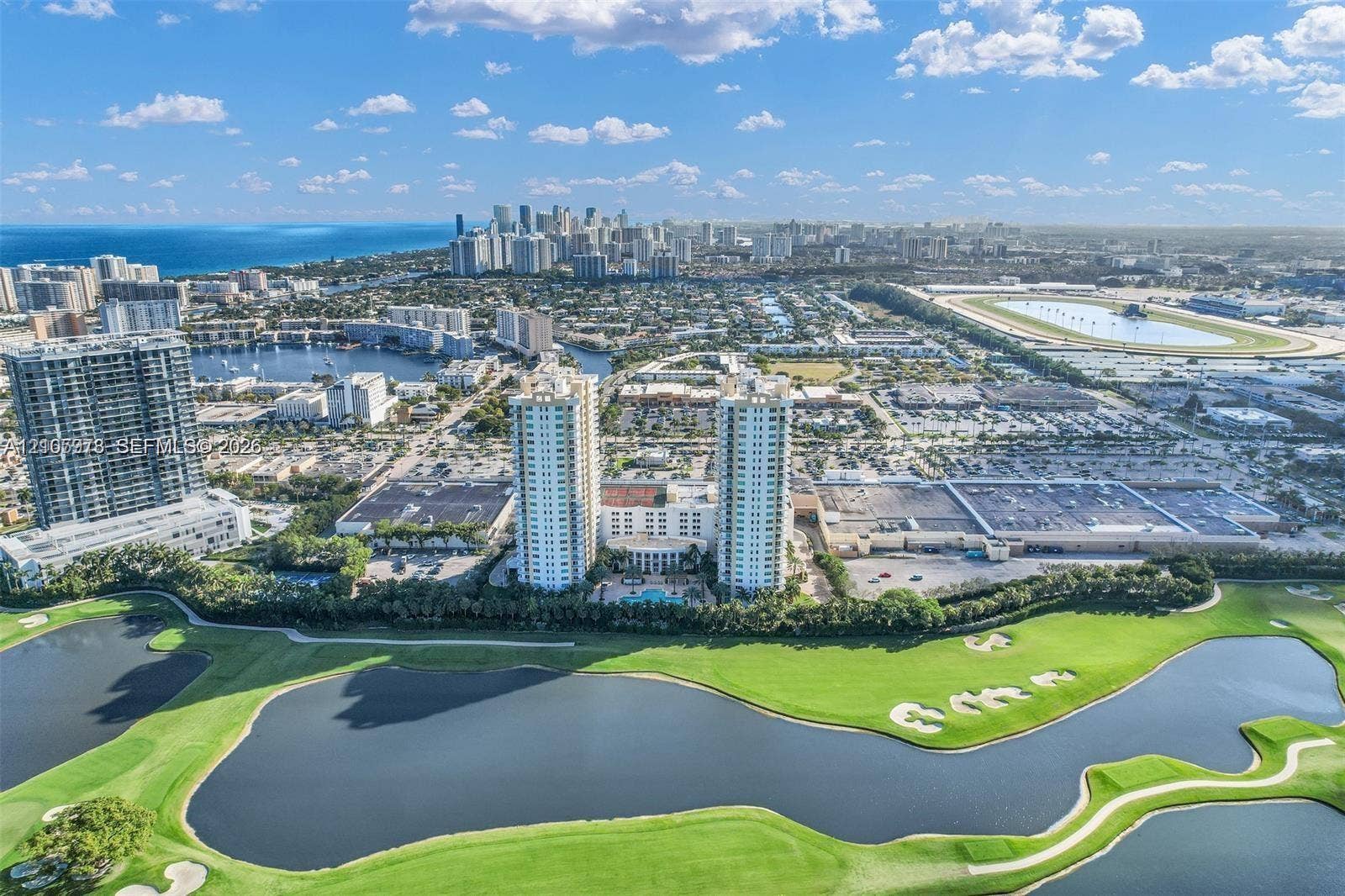 1755 E Hallandale Beach Boulevard, #704E, Hallandale Beach, Hallandale Beach, FL 33009 Aerial perspective featuring twin high-rise residential buildings situated on a golf course with expansive water features and mature landscaping