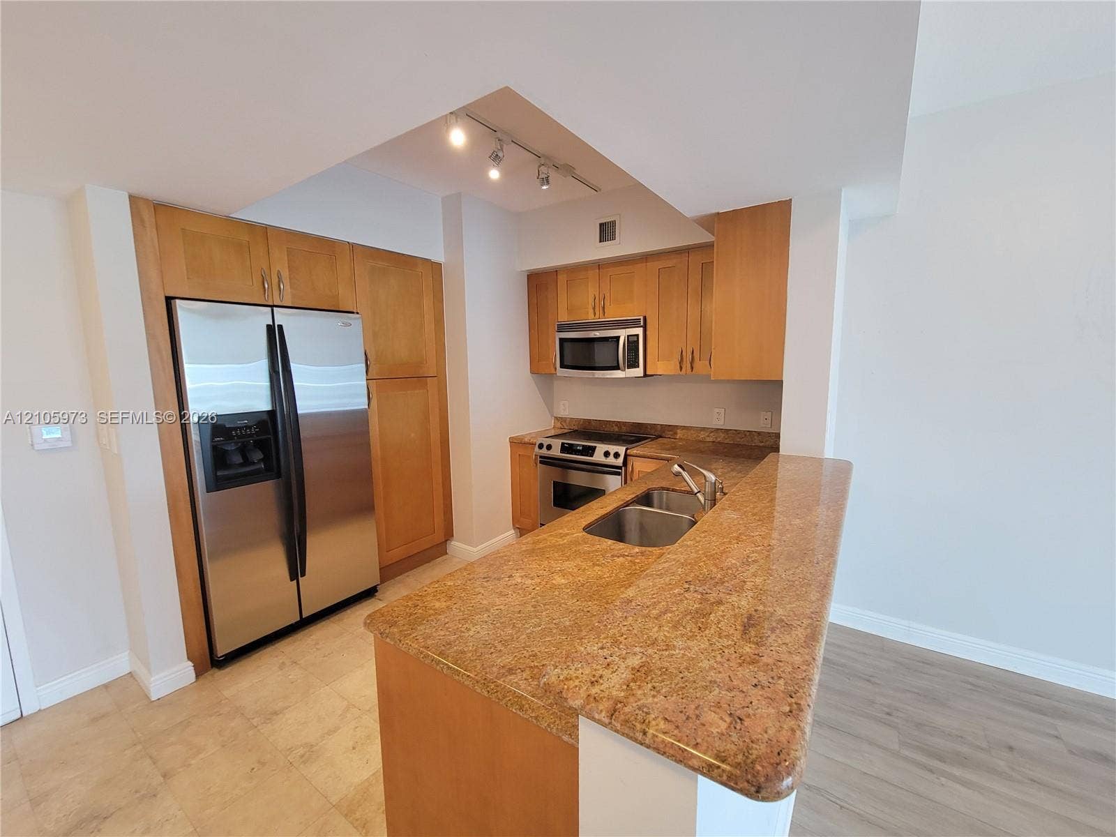 1755 E Hallandale Beach Boulevard, #704E, Hallandale Beach, Hallandale Beach, FL 33009 Kitchen featuring natural wood cabinetry, stone countertops, stainless steel appliances, a double-basin undermount sink, and recessed track lighting