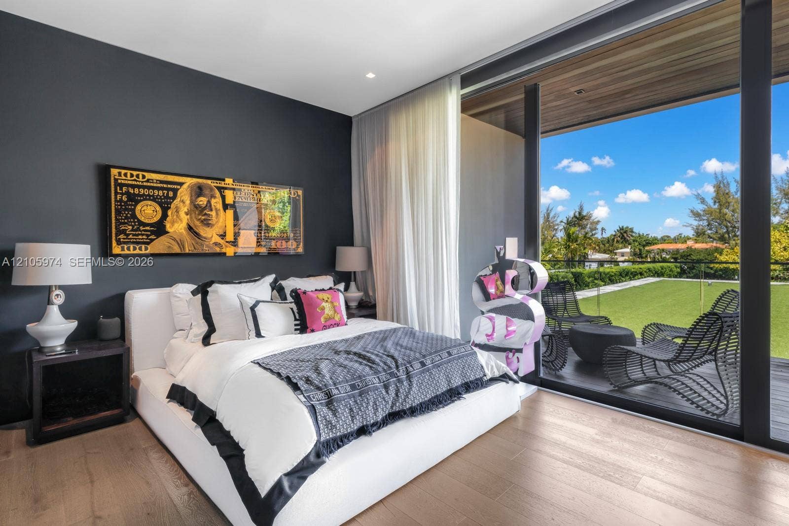 4395 Pine Tree Drive, Miami Beach, FL 33140 Floor-to-ceiling glass sliding doors, wood-finish flooring, dark-toned accent wall, and a recessed ceiling with wood-plank paneling