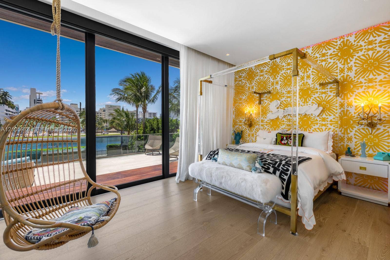 4395 Pine Tree Drive, Miami Beach, FL 33140 Floor-to-ceiling sliding glass walls, expansive terrace with wood-finish decking, glass-panel railing, and wood-finish flooring