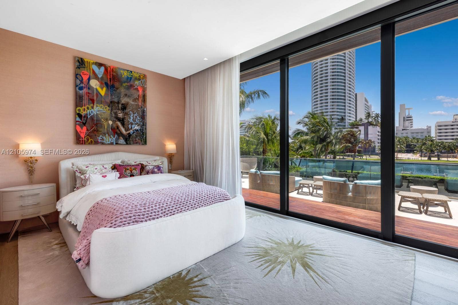 4395 Pine Tree Drive, Miami Beach, FL 33140 Floor-to-ceiling glass sliding doors, private balcony with wood-finish decking, glass railing, and neutral wall textures