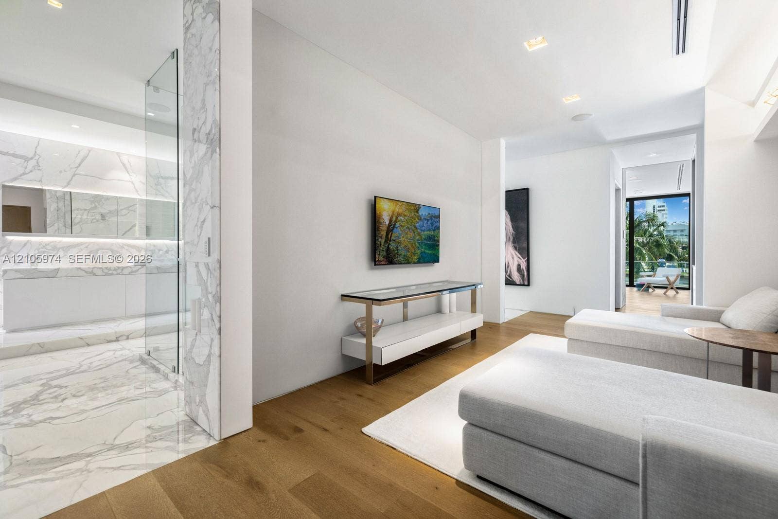 4395 Pine Tree Drive, Miami Beach, FL 33140 Wood-finish flooring, stone-clad bathroom surfaces, recessed ceiling lighting, and a glass-enclosed shower