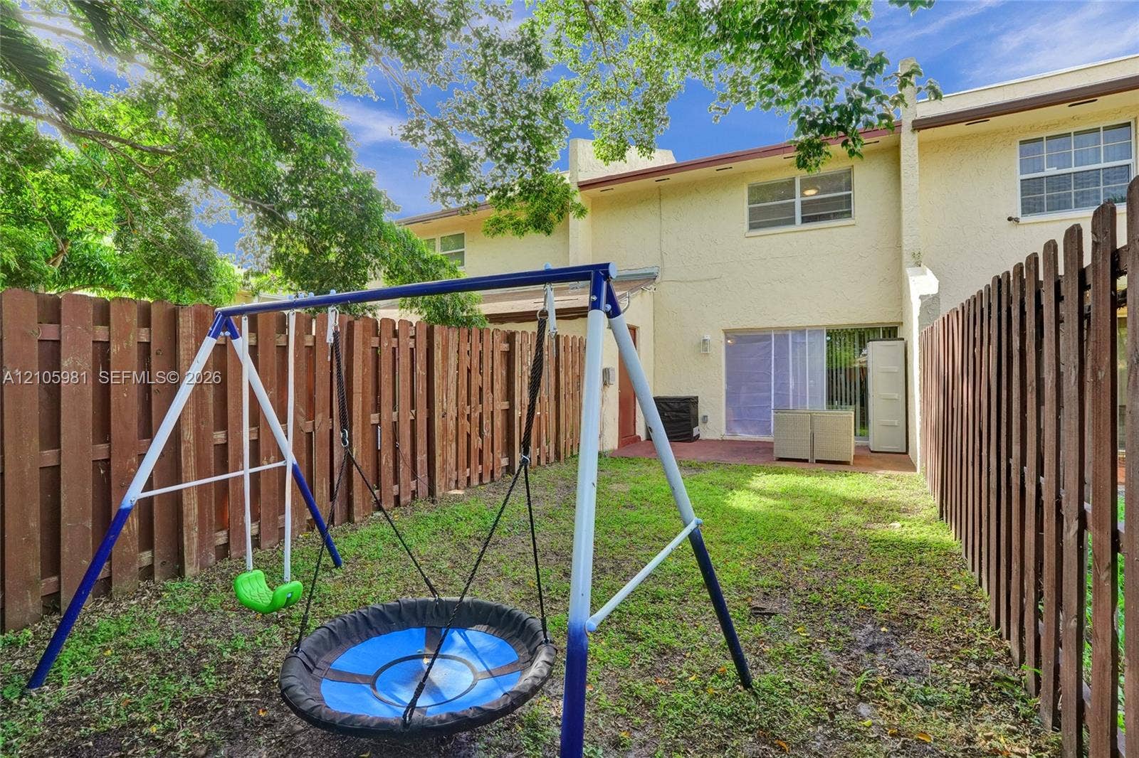 6813 NW 29th Avenue, Fort Lauderdale, Fort Lauderdale, FL 33309 Enclosed backyard featuring a concrete patio, wood privacy fencing, and exterior sliding glass door entry