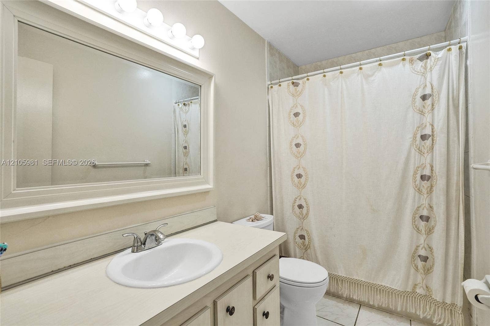 6813 NW 29th Avenue, Fort Lauderdale, Fort Lauderdale, FL 33309 Bathroom featuring a vanity with integrated sink, chrome-finish faucet, framed wall-mounted mirror, overhead multi-bulb lighting, and a tiled shower surround