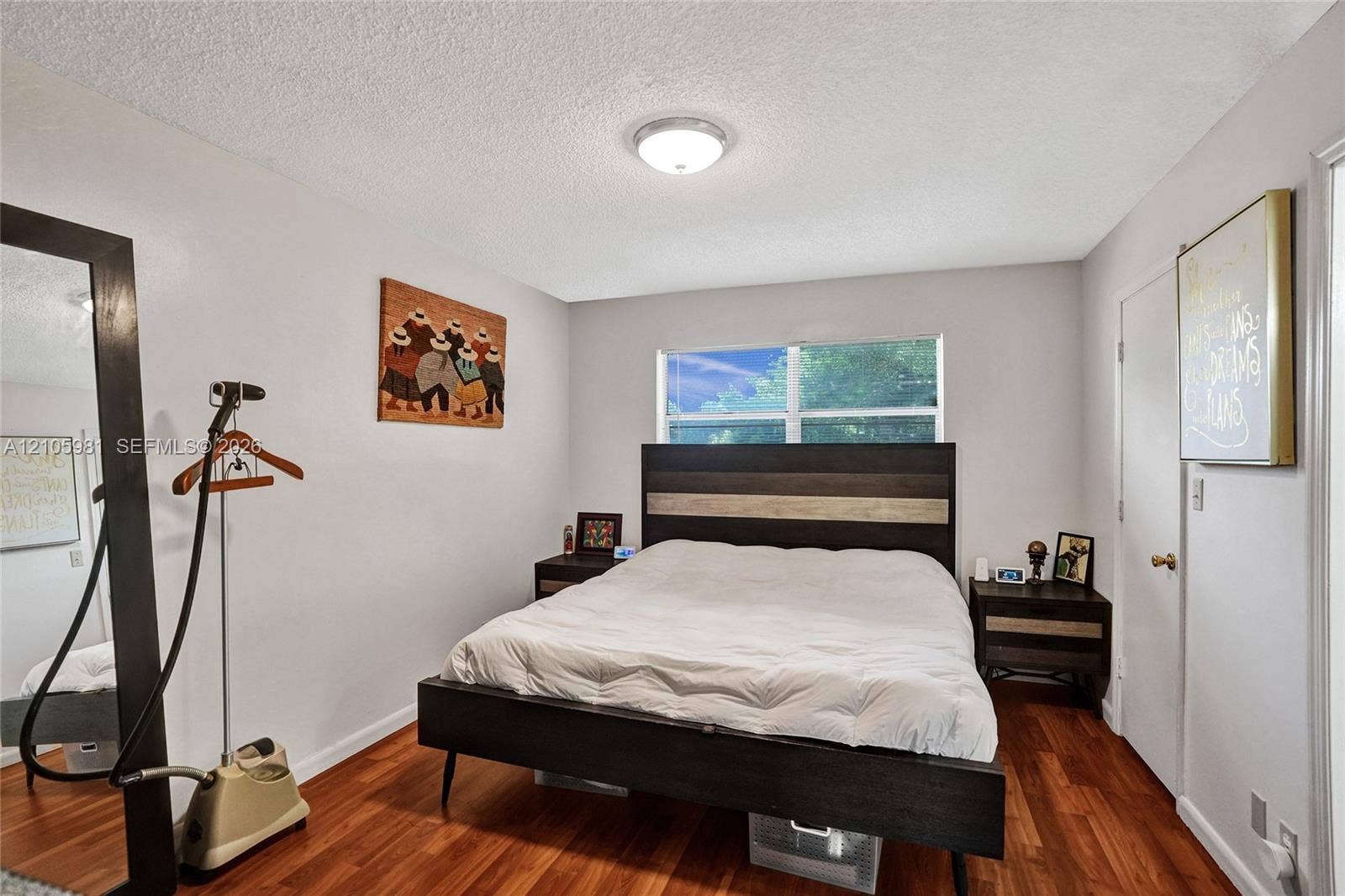6813 NW 29th Avenue, Fort Lauderdale, Fort Lauderdale, FL 33309 Room interior featuring wood-finish flooring, a double-hung window, and a flush-mount ceiling light fixture