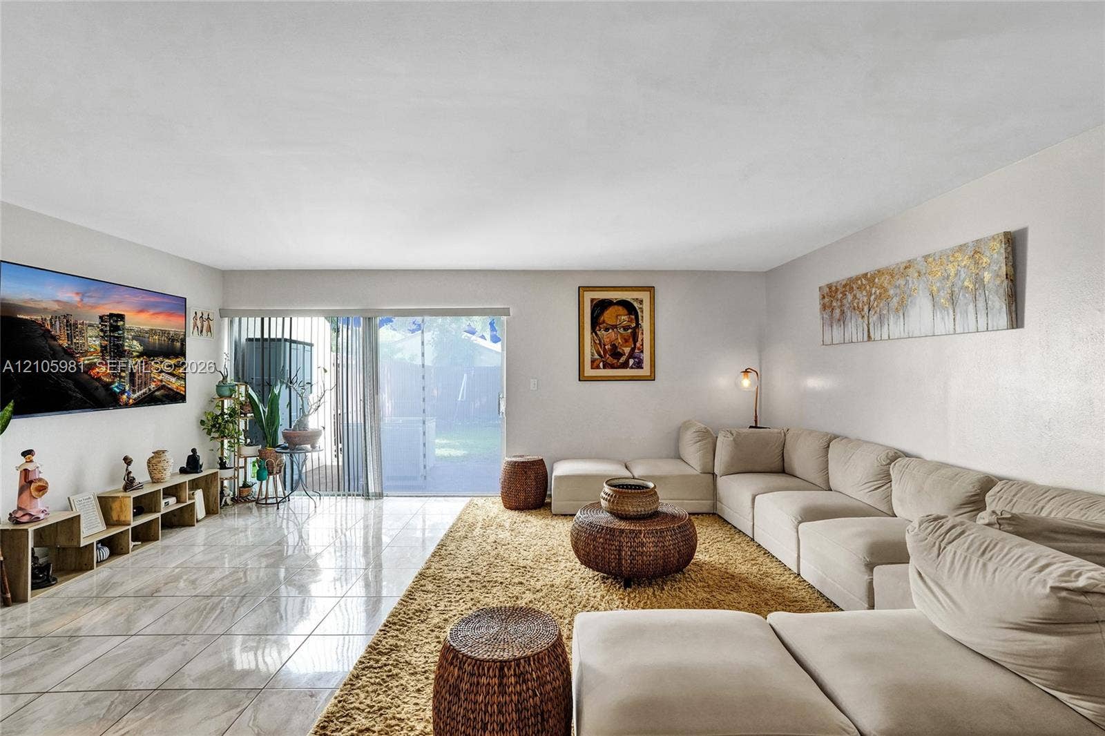 6813 NW 29th Avenue, Fort Lauderdale, Fort Lauderdale, FL 33309 Living area featuring polished tile flooring and a large sliding glass door with vertical blinds