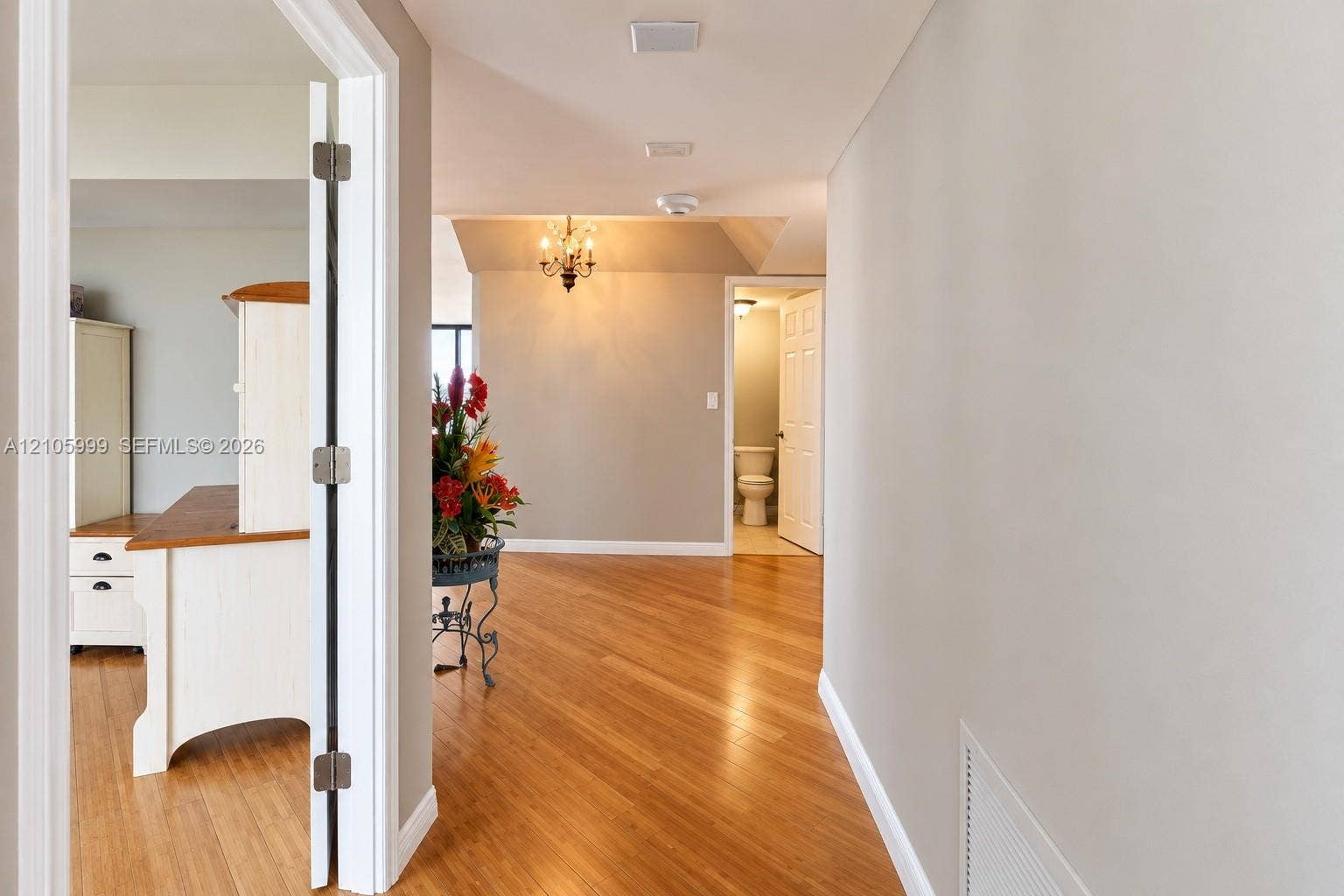Interior space featuring wood-finish flooring, recessed ceiling lighting, and a multi-arm chandelier